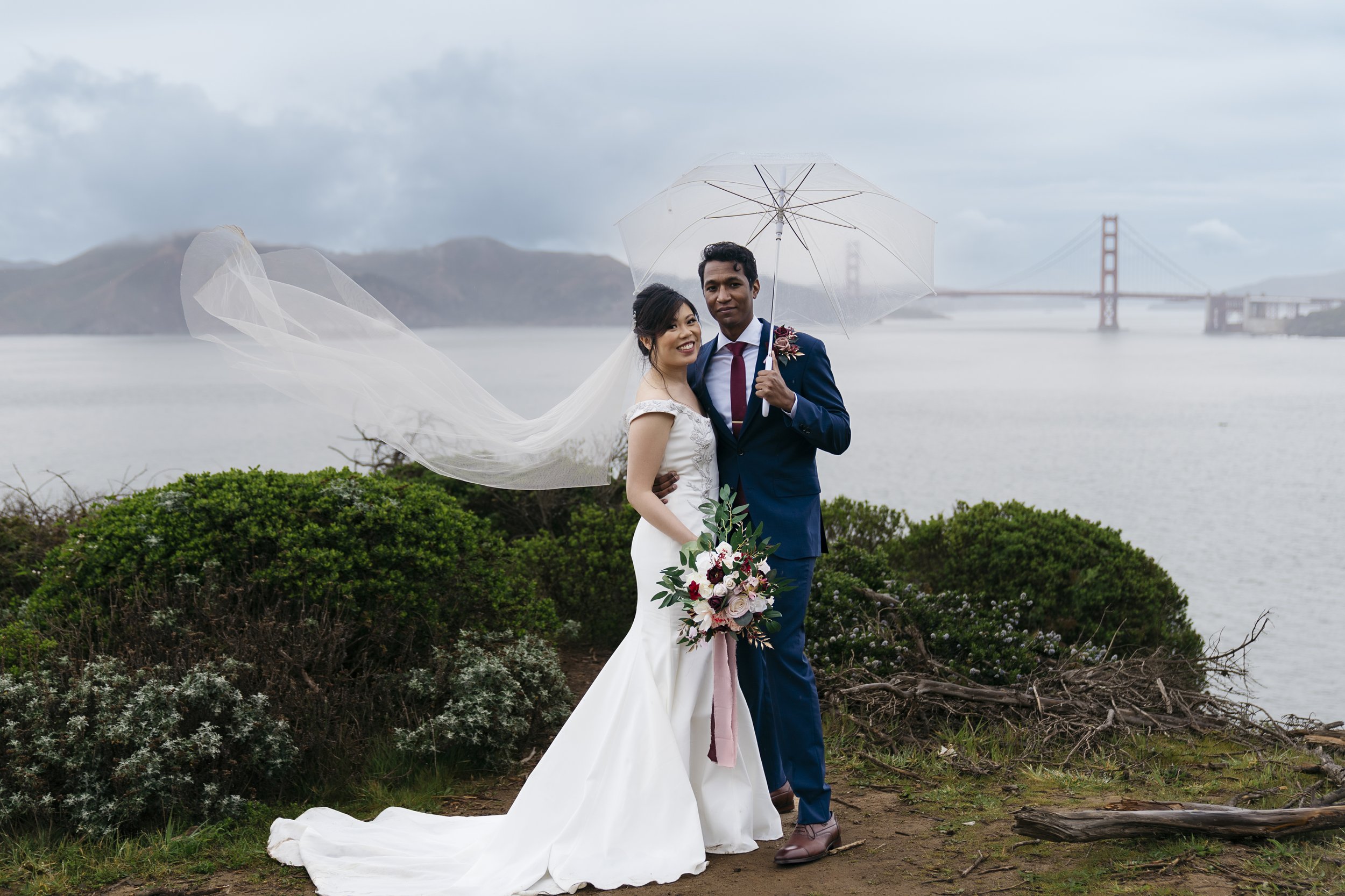 Couple posing for wedding pictures on a rainy day in San Francisco
