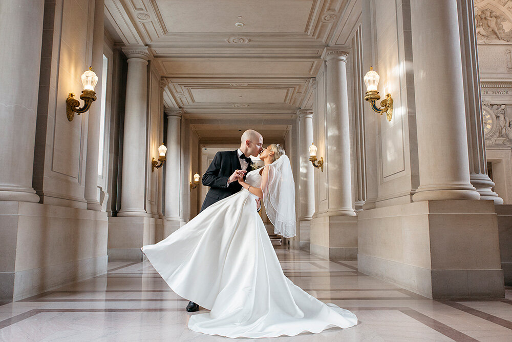 Photography of a groom Dipping the bride for a kiss in San Francisco City Hall
