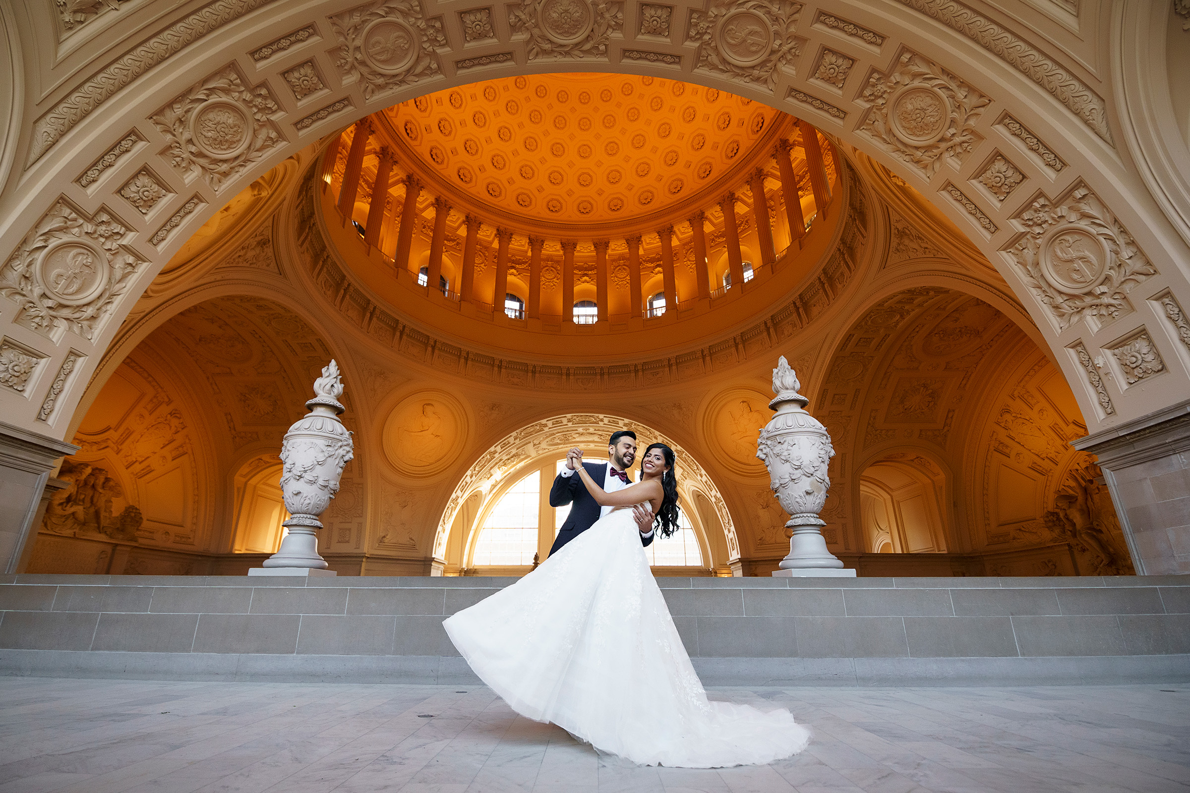 San Francisco City Hall Wedding Photo of Groom dipping his bride in the dome.