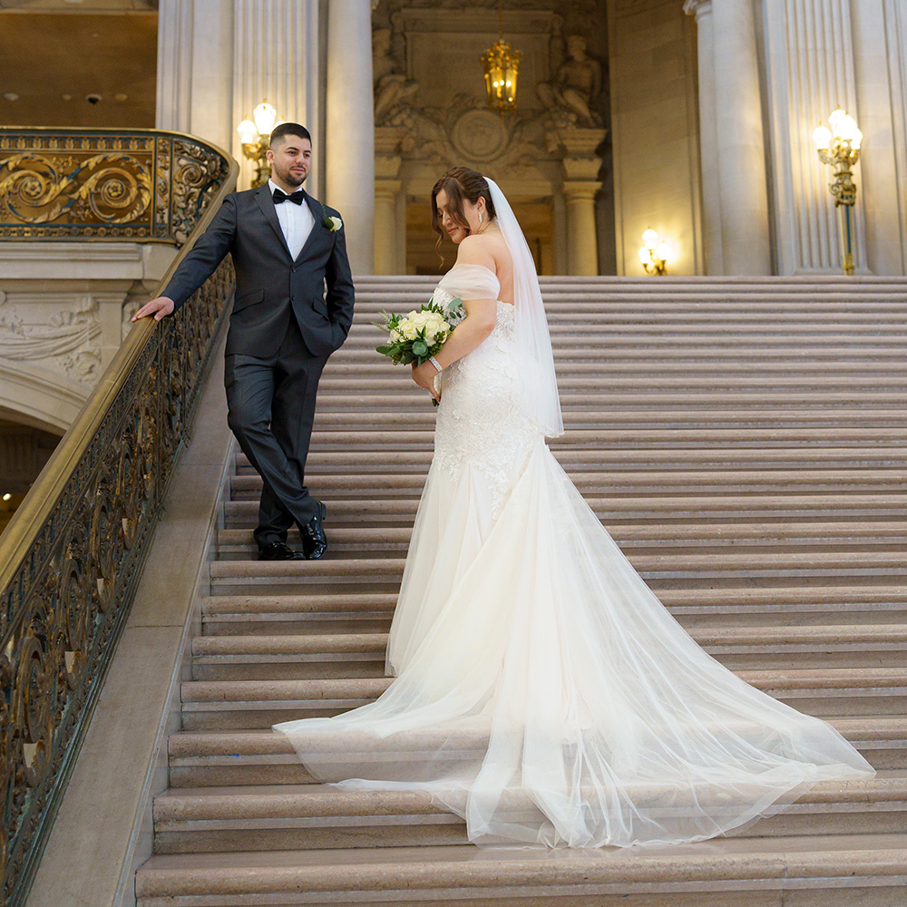 Photography of a Groom at SF City Hall Admiring his bride on the grand stair case