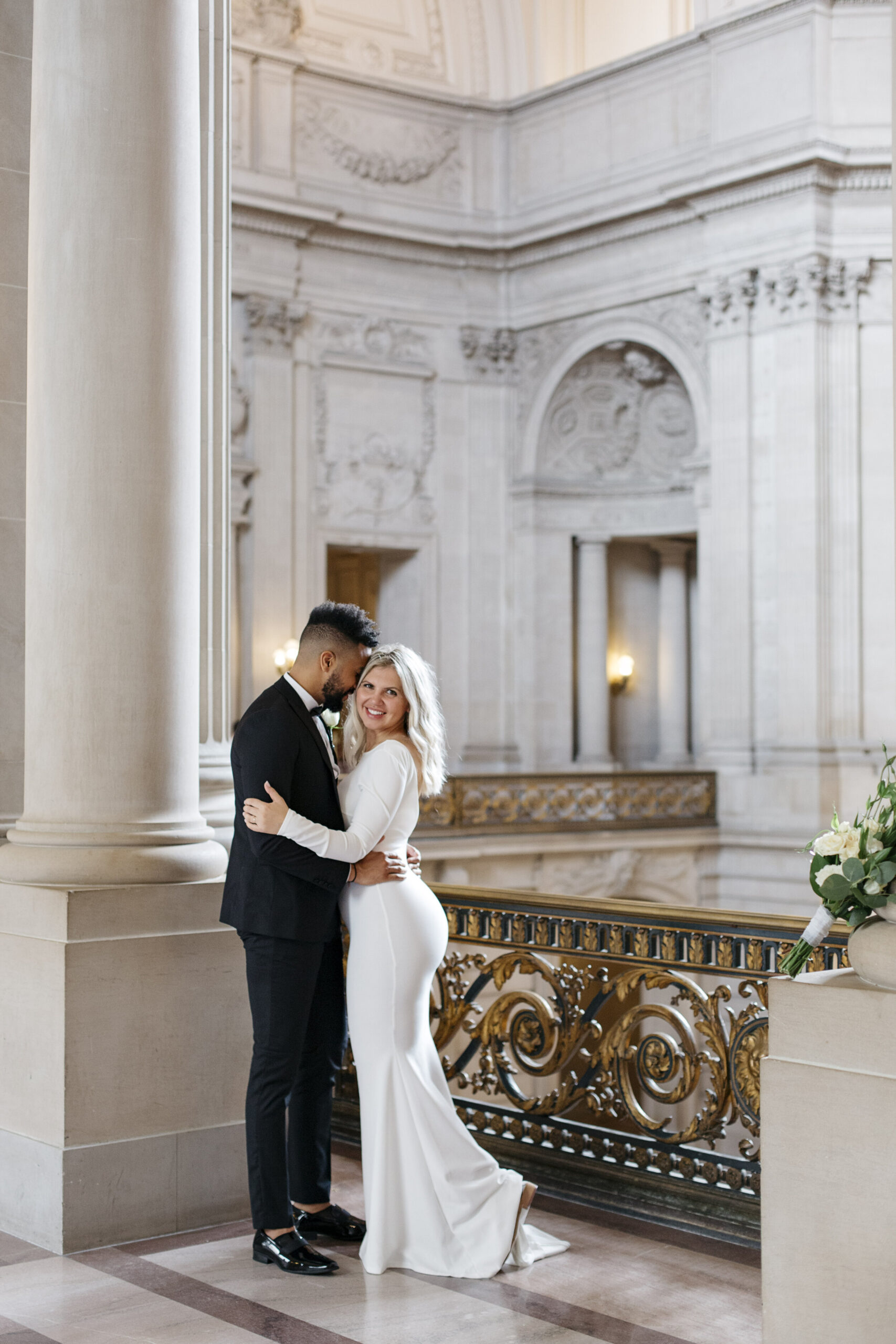 Couple posing on a balcony in San Francisco City Hall